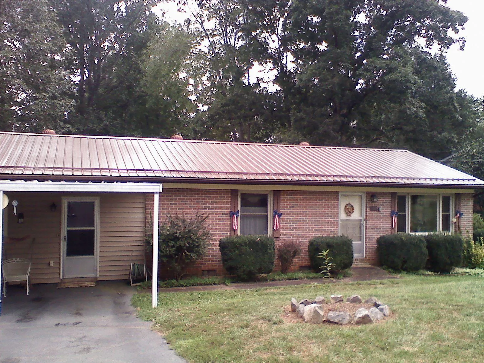 Bronze metal roof and carport on a brick ranch home — Roof Repair work by our crew in Chapmansboro